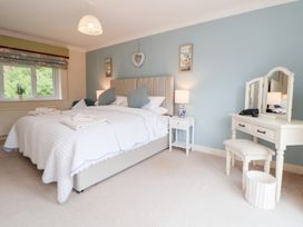 A bedroom with a bed and vanity table at The Old Barn in Pentre Celyn