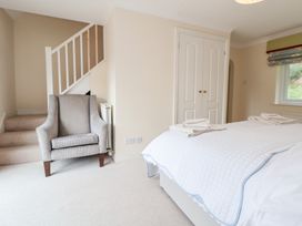 A bedroom with a bed and a chair at The Old Barn in Pentre Celyn