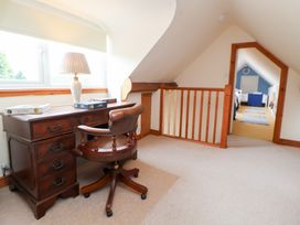 A landing area with a desk and chair at The Old Barn in Pentre Celyn