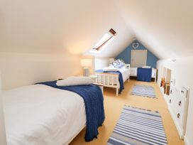 A bedroom with two beds and a lamp at The Old Barn in Pentre Celyn
