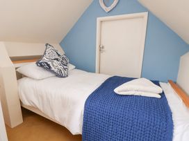 A bedroom with a bed and door at The Old Barn in Pentre Celyn