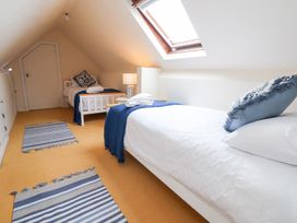 A bedroom with two beds and a lamp at The Old Barn in Pentre Celyn