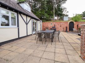 An outdoor patio with a table and chairs at The Old Barn in Pentre Celyn