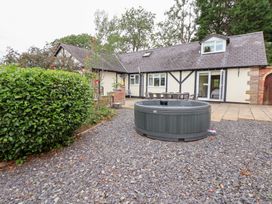 A garden with a hot tub and patio furniture at The Old Barn in Pentre Celyn