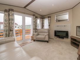 A living room with sofa and television at Aspen in Denny