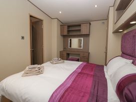 A bedroom with a bed and dresser at Aspen in Denny