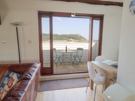 A living room with a table and chairs overlooking a balcony at Cliff View in Seaton