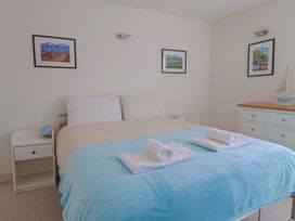 A bedroom with a bed, nightstand, and decorative items at Cliff View in Seaton