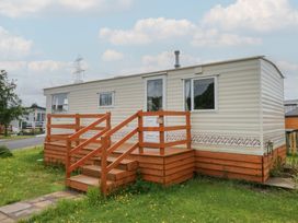 A mobile home with wooden steps and railing at Holly in Denny
