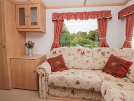 A living room with a sofa and a table at Holly in Denny