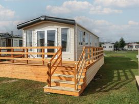 A mobile home with a wooden deck and steps at Yew in Denny