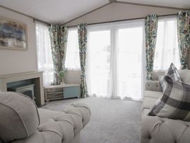 A living room with a sofa, table, and fireplace at Yew in Denny