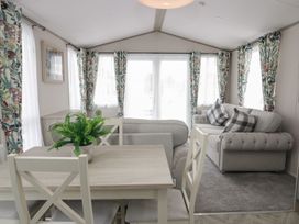 A living room with seating area and dining table at Yew in Denny