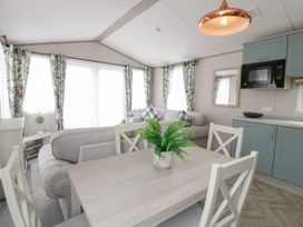 A living room with a sofa and dining table at Yew in Denny