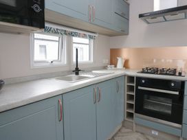 A kitchen with a sink and gas stove at Yew in Denny