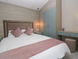 A bedroom with a bed and side tables at Yew in Denny