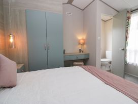A bedroom with a bed and wardrobe at Yew in Denny