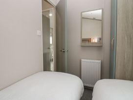 A bedroom with twin beds and a mirror at Yew in Denny