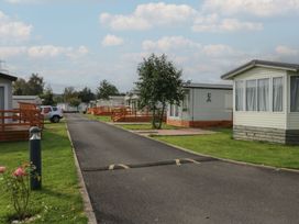 A pathway with mobile homes and trees at Yew in Denny