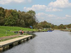 A scenic view of a waterway with docks and people sitting at The Yew in Denny