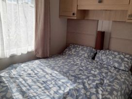 A bedroom with a bed and curtains at Yew in Denny