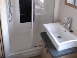A bathroom with a shower and hand basin at Yew in Denny