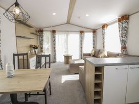 A living room with a sofa and dining area at Ash in Denny