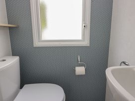 A bathroom with a toilet and sink at Ash in Denny