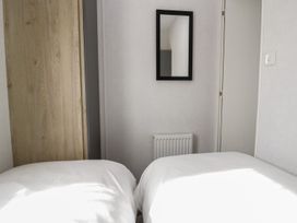 A bedroom with two beds and a mirror at Ash in Denny