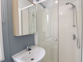 A bathroom featuring a shower, mirror, and sink at Ash in Denny