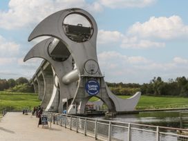 The Falkirk Wheel boat lift with water and grassy hills at Scottish Canals