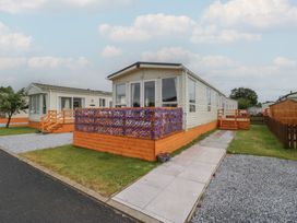 A mobile home with a decking area and a pathway at Willow in Denny
