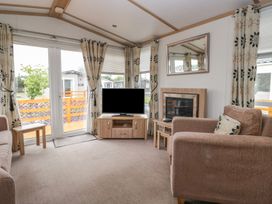 A living room with a television and fireplace at Willow in Denny