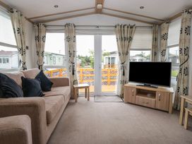 A living room with a sofa and television at Willow in Denny