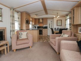 A living room with a sofa and kitchen area at Willow in Denny