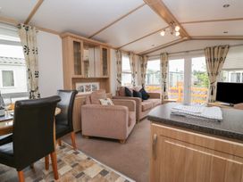 A living room with sofas and a dining area at Willow in Denny