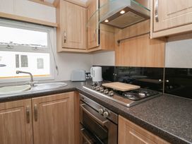 A kitchen with a gas stove and sink at Willow in Denny