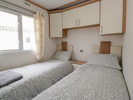 A bedroom with twin beds and window at Willow in Denny