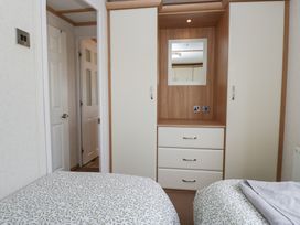 A bedroom with a wardrobe and mirror at Willow in Denny