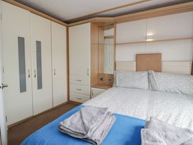 A bedroom with a bed and wardrobe at Willow in Denny