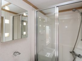 A bathroom with a shower and mirror at Willow, Denny