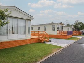 Caravans with wooden decking and grassy area at Willow in Denny
