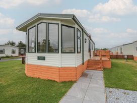 A mobile home with a deck and steps at Birch in Denny