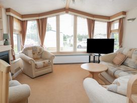 A living room with a sofa and television at Birch in Denny