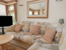 A living room with a sofa and television at Birch in Denny