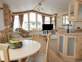A living room with a dining table and sofa at Birch in Denny