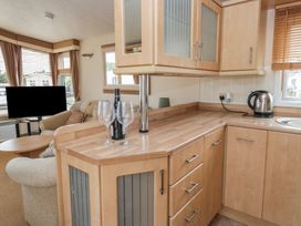 A kitchen with a countertop and television at Birch in Denny