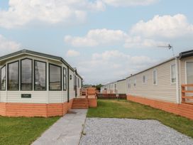 A caravan with a pathway and grass area at Birch in Denny