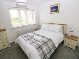 A bedroom with a bed and nightstands at 69 Ffordd Y Meillion in Llanelli
