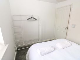 A bedroom with a bed and clothing rack at 69 Ffordd Y Meillion in Llanelli